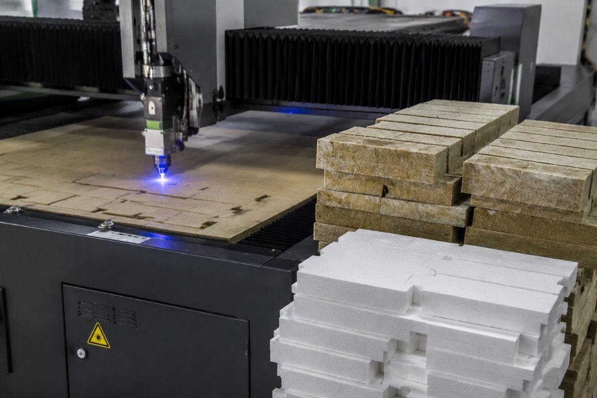 Clean cut edges from insulation CNC cutting machine Finished clean-cut rockwool and foam board pieces stacked next to a CNC cutting machine