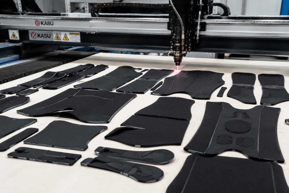 Clean cut neoprene parts from CNC cutting process Finished cut neoprene parts for wetsuit components laid out on a production table