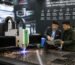 A CNC cutting machine being demonstrated at a regional industrial trade show, with a trader and end client reviewing product specifications